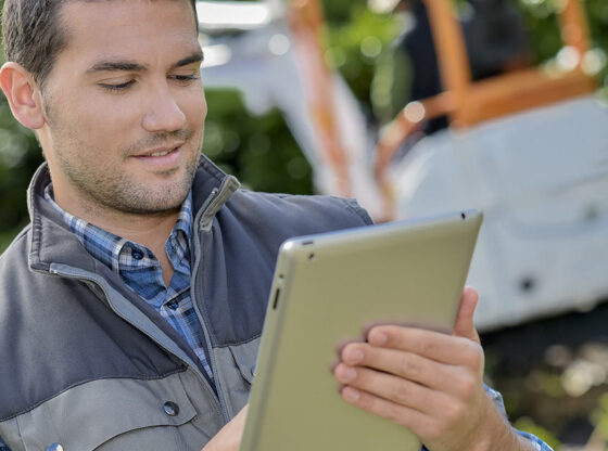 This image shows a green industry professional using landscape design software on a tablet.